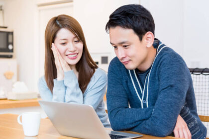 結婚式情報をPCで閲覧する夫婦
