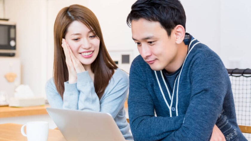 結婚式情報をPCで閲覧する夫婦