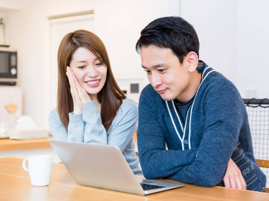 結婚式情報をPCで閲覧する夫婦